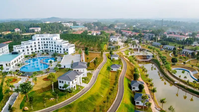 Toàn cảnh Glory Resort từ flycam: tòa nhà trắng, bể bơi, dãy biệt thự và hồ nước