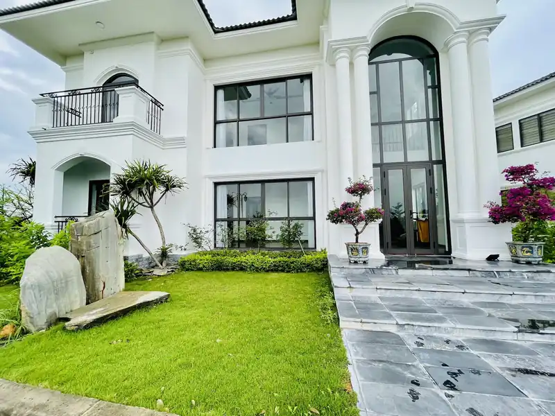 Osaka Villa tại Glory Resort: biệt thự hai tầng trắng, cửa vòm kính cao, sân cỏ và đá cảnh