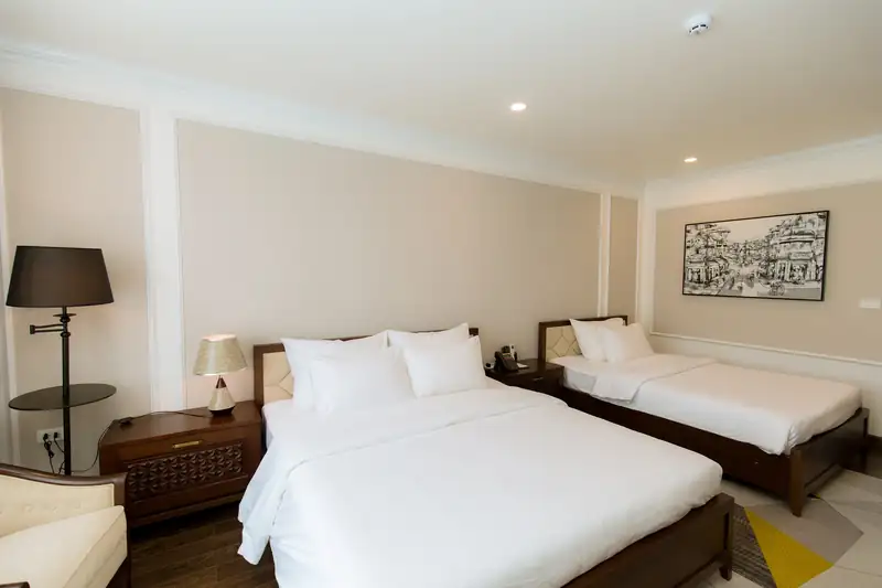 Phòng Deluxe Twin Pool View hai giường, đèn cây và tranh phố cổ trên tường