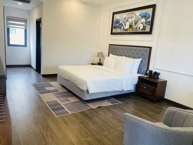 Phòng King Garden giường lớn đầu giường bọc nỉ xám, tranh sen treo tường, sàn gỗ tối màu