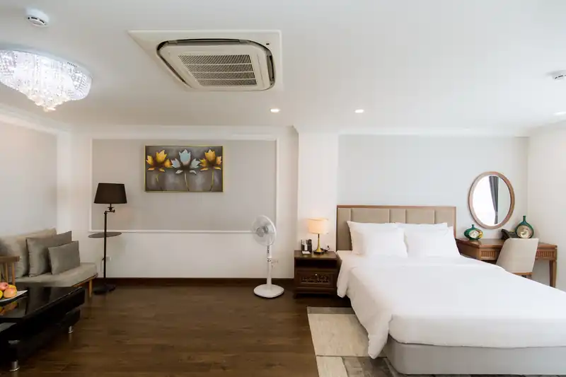 Phòng Suite Pool View rộng rãi tại Glory Resort với sofa, giường đôi và đèn chùm pha lê