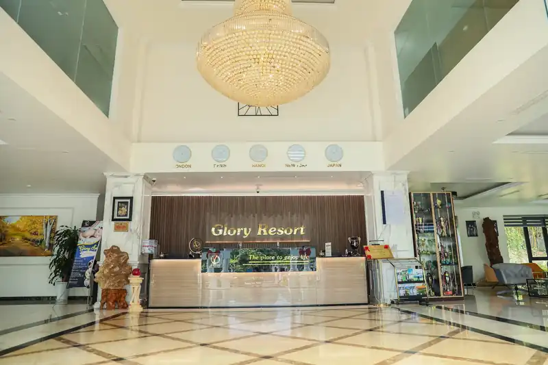 Sảnh lễ tân Glory Resort với đèn chùm pha lê, sàn đá cẩm thạch và quầy lễ tân ốp gỗ tối