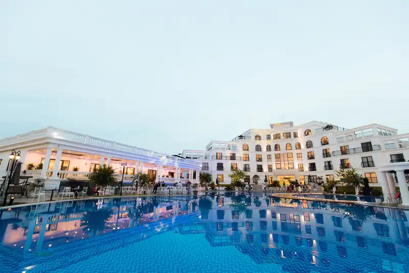 Glory Resort lúc chiều buông: tòa nhà trắng tân cổ điển soi bóng xuống mặt bể bơi ngoài trời