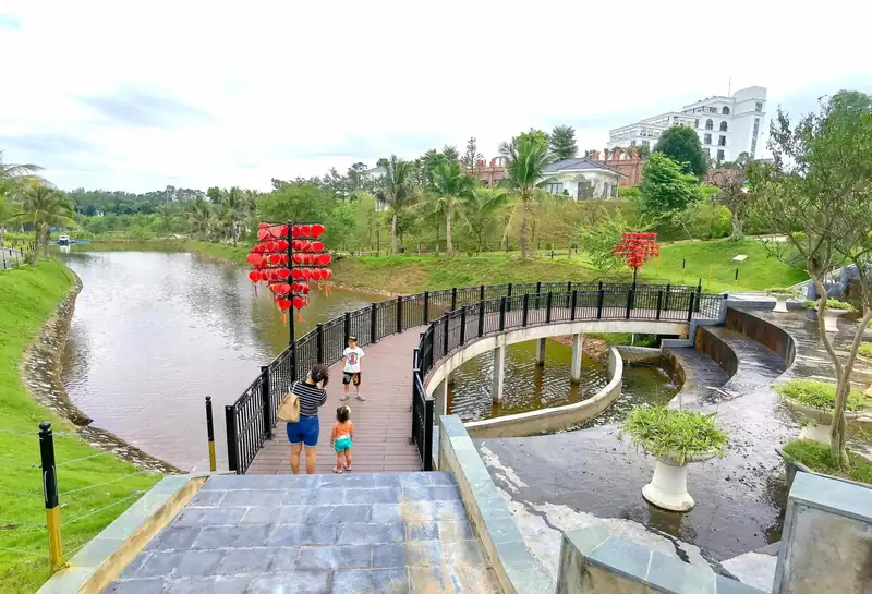 Cầu Tình yêu ở Glory Resort lát gỗ uốn cong qua hồ, cây treo lồng đèn trái tim đỏ